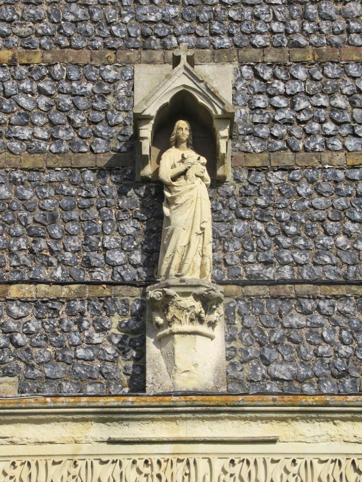 Sculpture figure on flint masonry